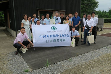 写真02.中国木材保護工業協会視察団の8名の方々と事件住宅の前で」の集合写真