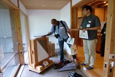 写真10.木質耐震・快適性工学実験棟のなかで展示物を森林総合研究所の構造利用研究領域長が研修員に説明している様子