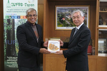 理事長室での表敬訪問で、マレーシア森林研究所副所長から沢田理事長に、同所の出版図書が贈られる様子