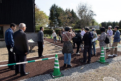 写真7：住宅周囲の高性能木質舗装路について説明を聞いている様子