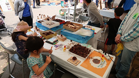 写真1.松ぼっくりや端材を使って作品をつくる子供達