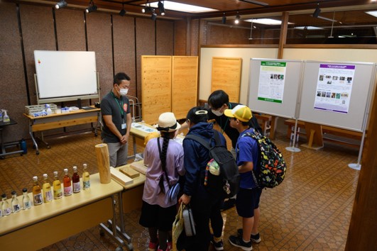 写真2.木の酒を作る過程の説明を熱心に聞いている写真