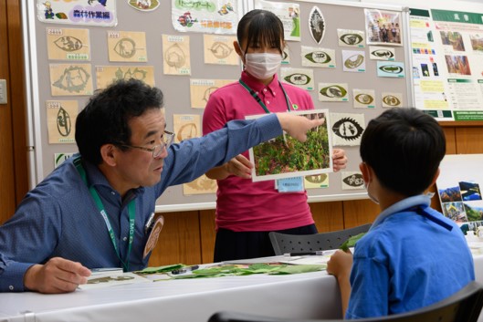 写真5.葉っぱで作るリーフアートの説明をしている写真