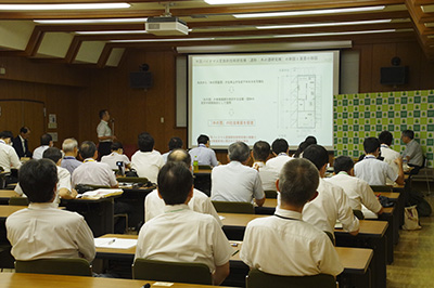 「木の酒」製造技術の概要、研究の進捗状況を聴講している様子