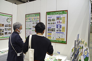 研究成果のポスターを注視している来場者の様子