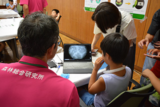 写真6.葉っぱの表面からプレパラートを作成して顕微鏡に映し出された気孔を興味深く観察している様子