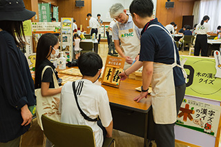写真9.木に書かれた漢字の「へん」と「つくり」を組み合わせてパズルに挑戦