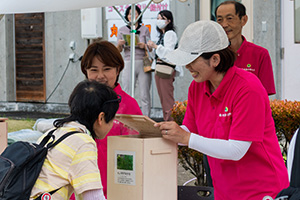 木製の箱の蓋を持ち上げて、ディフューザーから出るヒノキアスナロ（ヒバ）の香りを体験している写真