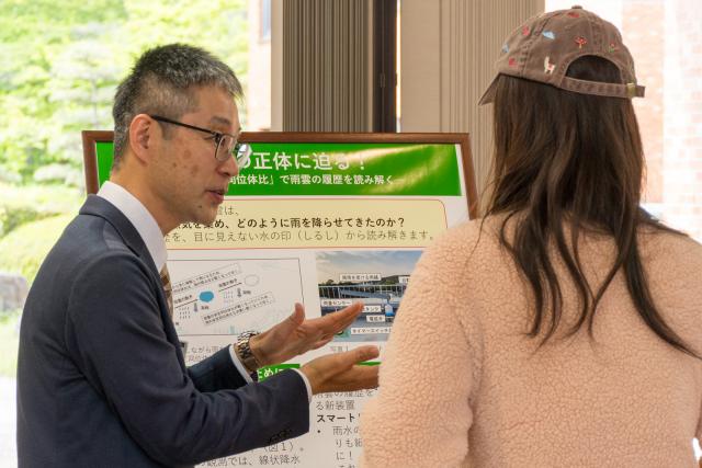 研究担当者がポスター前で解説している様子