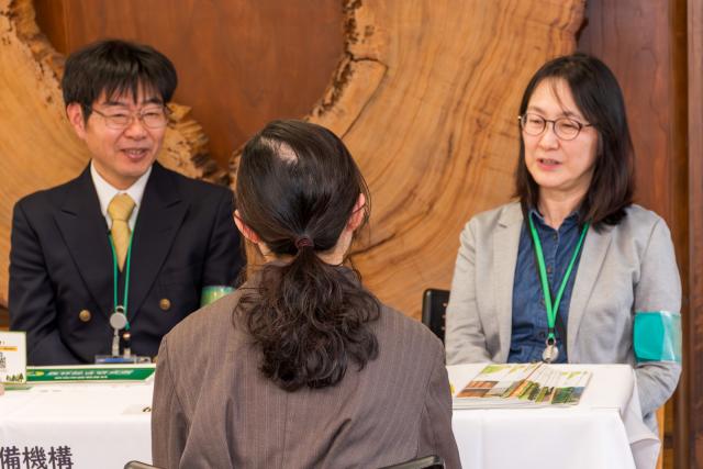 大学生から研究に関する仕事について相談を受け、担当者が回答している様子