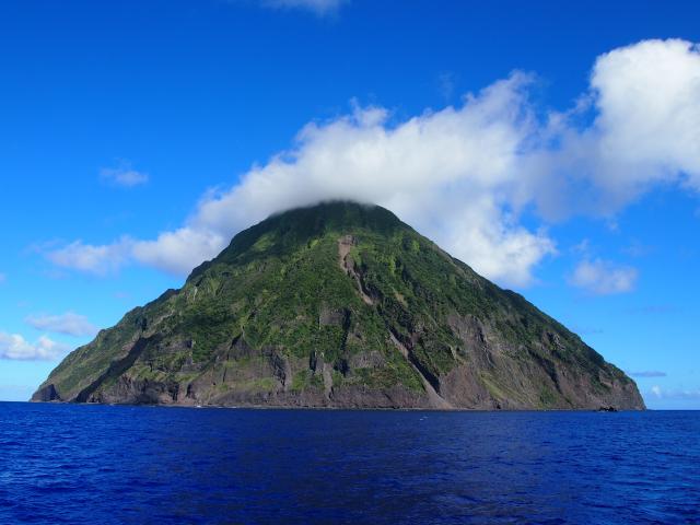 小笠原諸島の海上に浮かぶ南硫黄島。おにぎりのようなシルエットの三角の島で、森の中で多くの海鳥が繁殖する。